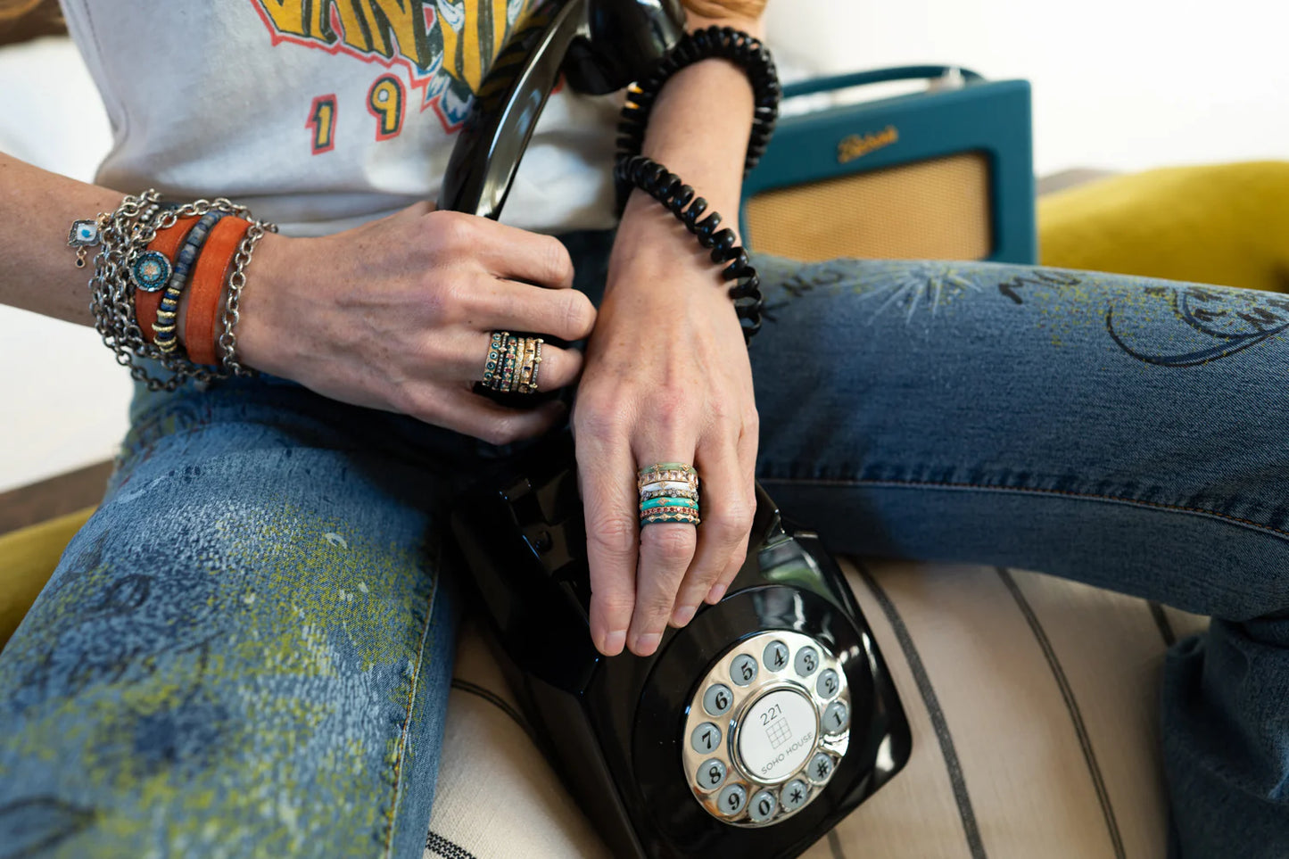 model sitting down showing off her ring on her hand holding a phone