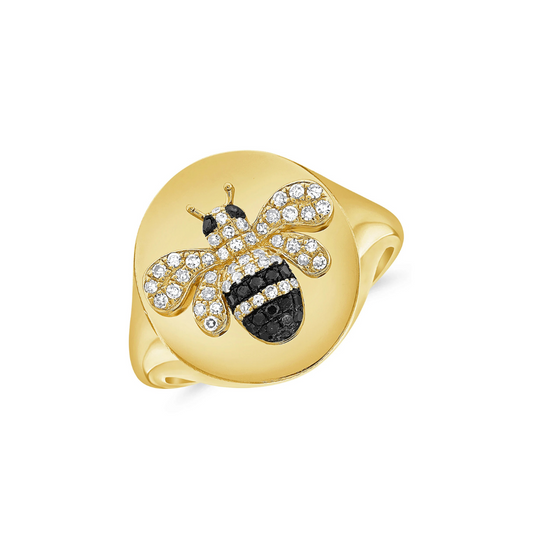 gold ring with a diamond and gemstone bee on it