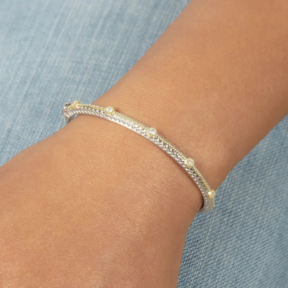 a model wearing the gold and silver bangle with diamonds