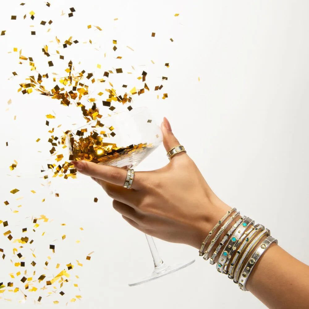 model cheers a glass with confetti in it with bangles on her wrist
